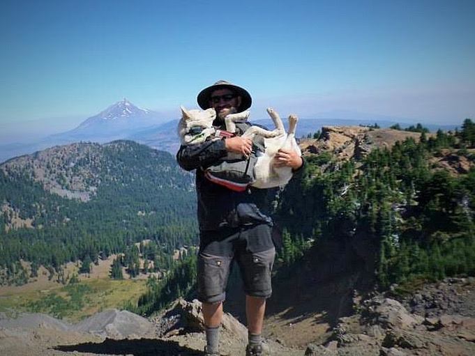 Dan Fent with dog Kaya on top of Three Finger Jack's East Ridge with a view of Mt. Jefferson